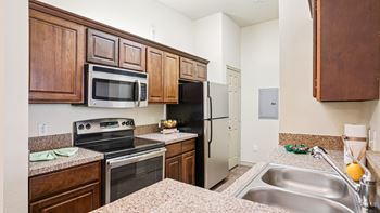 A kitchen with brown cabinets and a stove top oven.